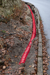 Network Buildout high-speed Internet Network cables in red Cable Protector Wire Cover are buried underground on