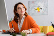 © LIGHTFIELD STUDIOS - happy designer looking away while working on graphic tablet at home