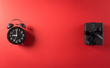 Wall Mural - Top view of Black Friday Sale text with Alarm clock and gift box on red background. Shopping concept boxing day and Black Friday composition.