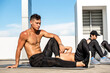 Diversity fit male bodybuilder group doing bodyweight exercise outdoors on building rooftop