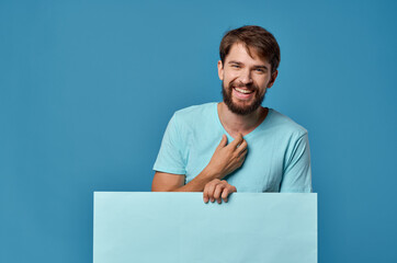 Poster - Cheerful man blue banner in hand blank sheet presentation isolated background