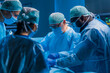 © Acronym - Multiracial team of professional medical surgeons performs the surgical operation in a modern hospital. Doctors are working to save the patient. Medicine, health, cardiology and transplantation.