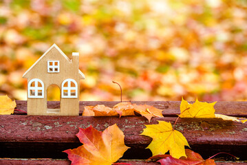 The symbol of the house stands among the fallen autumn leaves
