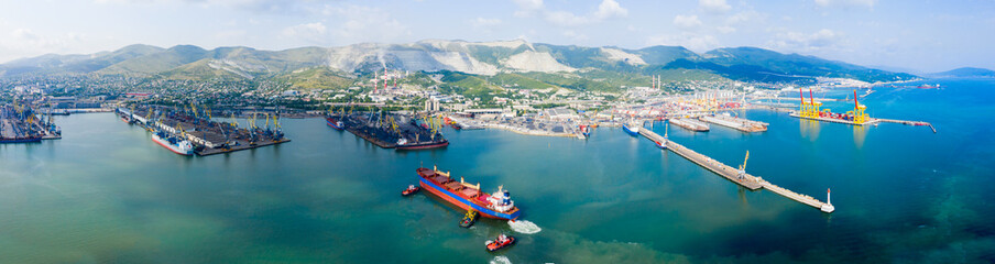 Industrial seaport Novorossiysk , top view. Port cranes and cargo ships and barges. Loading and shipment of cargo at the port. View of the sea cargo port with a bird's eye view.