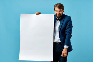 Poster - Cheerful man white banner in hand blank sheet presentation blue background