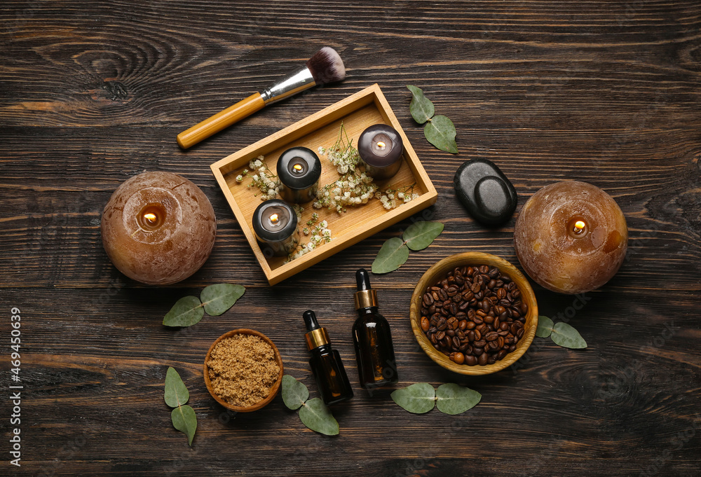 Beautiful spa composition with burning candles and coffee beans on wooden background