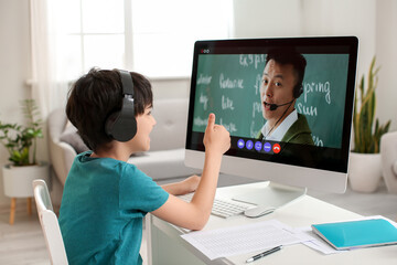 Little boy studying English language online at home