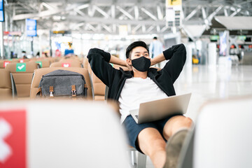 Wall Mural - New Normal and travel bubble concept.COVID-19 Travel Airport Asian man tourist boarding plane for holiday wearing medical face mask protection Coronavirus disease (Covid-19) infection in airport