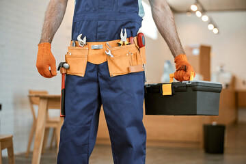 Male electrician in gloves holding tool box set