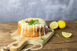 Classic lemon loaf cake on a wooden board, garnished with frosting and lemon shavings. Fast and tasty dessert