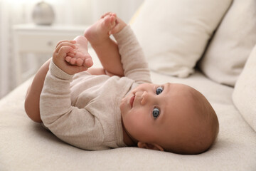 Sticker - Adorable little baby lying on sofa at home