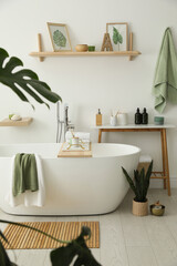 Wall Mural - Stylish bathroom interior with modern tub, houseplants and beautiful decor. Home design