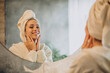 © Petro - Woman at home applying cream mask