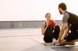 Young man and woman working out with medicine ball together on parking