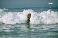 Happy Adult Man Tourist Having Fun In Indian Ocean With Small Splashing Waves Near Coastline, Goa