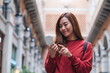 © Farknot Architect - A young asian woman holding and using mobile phone while traveling and sightseeing around the city