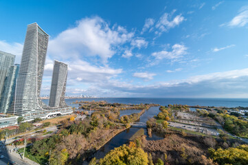 Wall Mural - Drone photo of Humber bay lakeshore and Parklawn rd area with blue skies with broken clouds fall tree colours yellow and orange green as well 