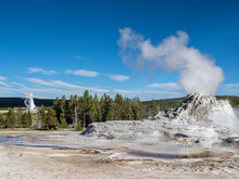 Castle Geyser Steaming, With Old Faithful Erupting Behind, In Yellowstone National Park, UNESCO World Heritage Site
