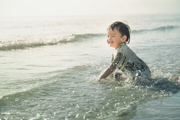 2 years old baby boy playing sand on the beach,Holidays with baby summer concept.