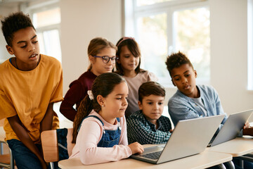 Wall Mural - Group of school kids use laptop during computer class at elementary school.