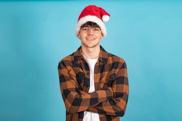 Poster - young man with santa claus hat isolated on blue colored background