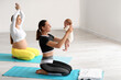© Pixel-Shot - Young pregnant woman doing yoga with trainer and little baby at gym