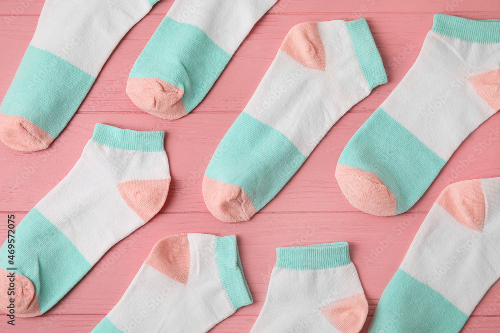 Many socks on pink wooden background, closeup