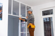 © Angelov - Construction worker installing metal profile for interior partition wall, while building a new house or renovation process, viewed from his back.