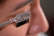 © Fabián Montaño - Close-up macro of young Latin woman using eyebrow comb.