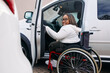 © PICHA - woman in a wheelchair getting in a car