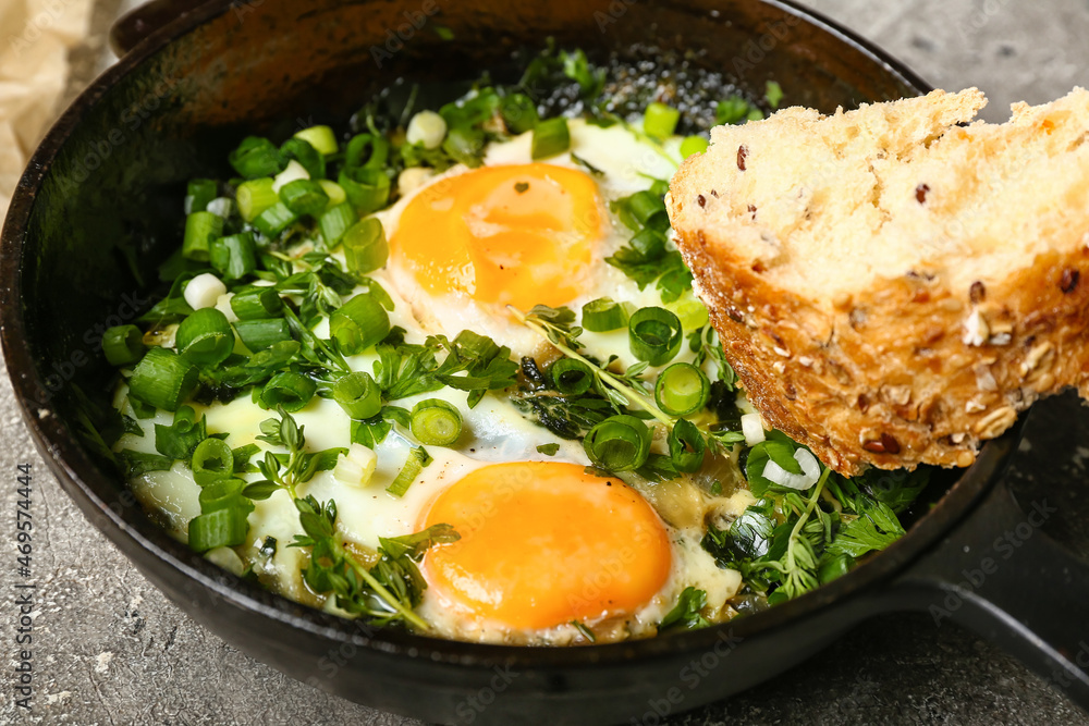 Frying pan with tasty Shakshouka on grunge background, closeup