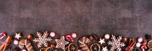 Christmas Baking Bottom Border With Cookies, Peppermints And Spices. Top Down View On A Dark Stone Background With Copy Space. Holiday Baking Concept.