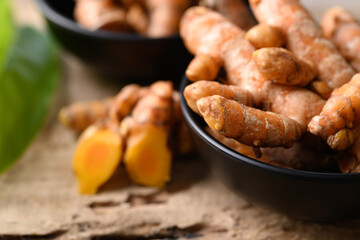 Fresh turmeric in a bowl on wooden background, Food ingredients in Asian food and used in beauty spa and herbal medicine