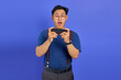 © Bangun Stock Photo - Shocked Asian young man playing video game on smartphone on purple background