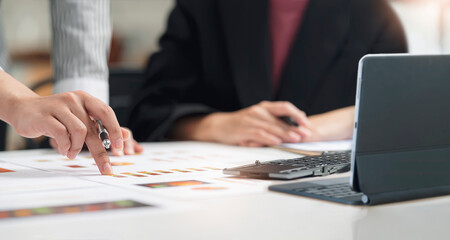 Wall Mural - Cropped shot of business people hands pointing on graph chart.