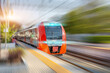 © aapsky - Railway station and passing suburban train with motion blur effect. Convenience concept of passenger transportation urban infrastructure.