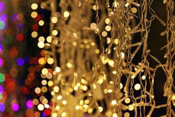 Wall Mural - Festive lights on electric garlands. Colorful Christmas decorations, New Year illumination in city