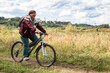© Zuev Ali - Cheerful grandmother rides a bicycle in nature.