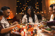 © Syda Productions - holidays, party and celebration concept - multiethnic group of happy friends having christmas dinner at home