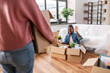 © Syda Productions - moving, people and real estate concept - happy smiling woman unpacking boxes at new home and waving hand