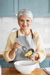 © Syda Productions - people and culinary concept - happy smiling woman cooking food on kitchen at home and adding butter