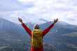 © New Africa - Happy woman with backpack admiring mountain landscape, back view. Feeling freedom