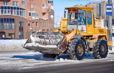 Wall Mural - Snow removing. Wheel loader cleaning road from snow.. Heavy duty loader clears road after heavy snowfall.