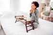 © deagreez - Portrait of attractive cheerful wavy-haired girl sitting in bed eating tasty yummy meal having fun at light home house indoors