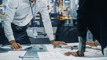 Leinwandbilder - Two Young Automotive Engineers Working in Office at Car Factory. Industrial Designer and Colleague Discussing Different Applications of a Metal Pinion Gear in Personal Mobility Vehicles.