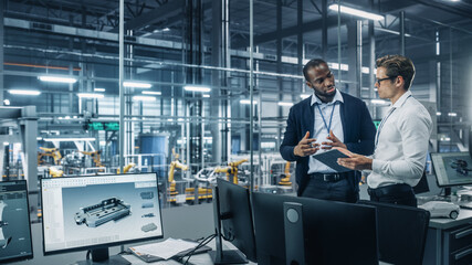 Sticker - Two Diverse Automotive Industrial Engineers Talking About Vehicle Production while Standing in Office at a Car Assembly Plant. Industrial Specialists Discuss Work Projects on Tablet Computer.