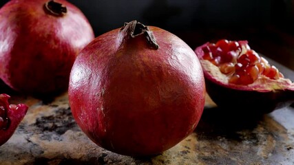 Poster - Whole pomegranate fruit rotating on a table