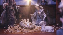 Jesus Christ Nativity Scene With Figurines In Stable And Light Particles. Jesus Christ Birth In A Manger With Mary And Joseph. Christmas Scene. Dolly Shot 4k