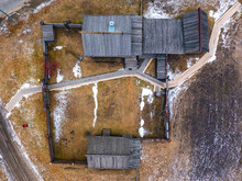 Wooden Village House In Russia Of The 19th Century, Outbuildings And A Yard With Tools, A View Vertically Down From Drone.