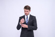 © Aleksandr - Portrait of elegant young caucasian handsome businessman in formal suit standing Isolated on white background in studio. Straightening cufflinks